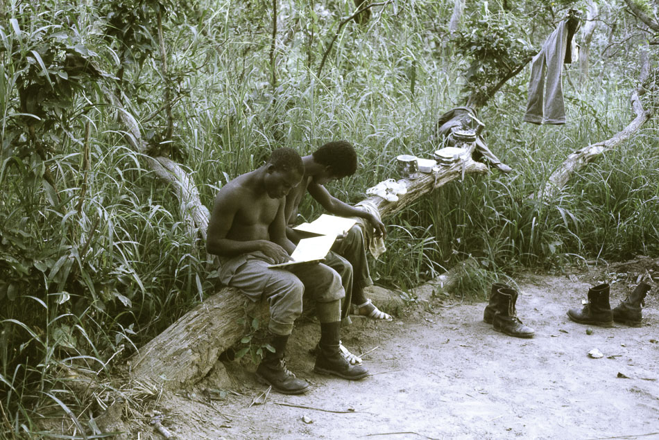 PAIGC militant combatants use their resting time to learn to read and write, putting into practice one of the Party Watchwords to ‘demand from responsible workers of the Party that they devote themselves seriously to study … [and] constantly improve their knowledge, their culture, their political training … [and] constantly learn’, 1974. Source: Roel Coutinho, Guinea-Bissau and Senegal Photographs (1973–1974)